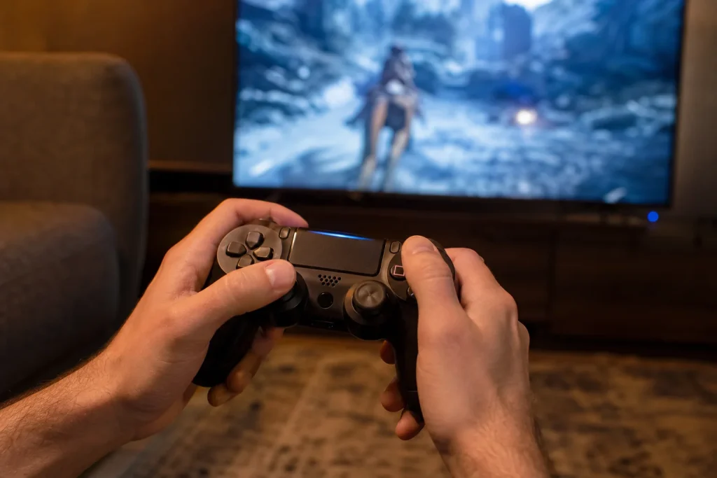 Närbild på händer som styr en handkontroll framför tv:n under en spelomgång av Golden Axe remake.
